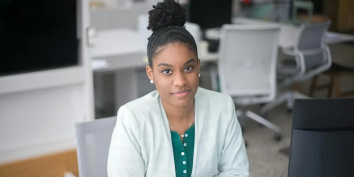 A woman sitting in a desk in front of a computer.
