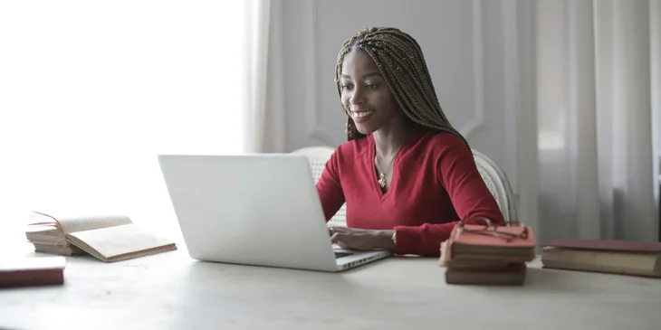 A woman sitting in an office in front of a laptop.