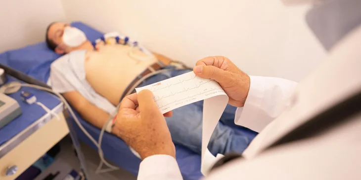 An EKG technician reviewing the patient's cardiac results.