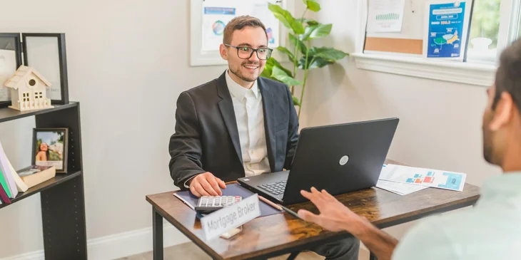 A man talking to a client in an office.
