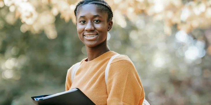 A happy woman holding a folder.