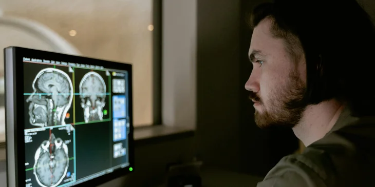An MRI technician reviews the scans on a computer.