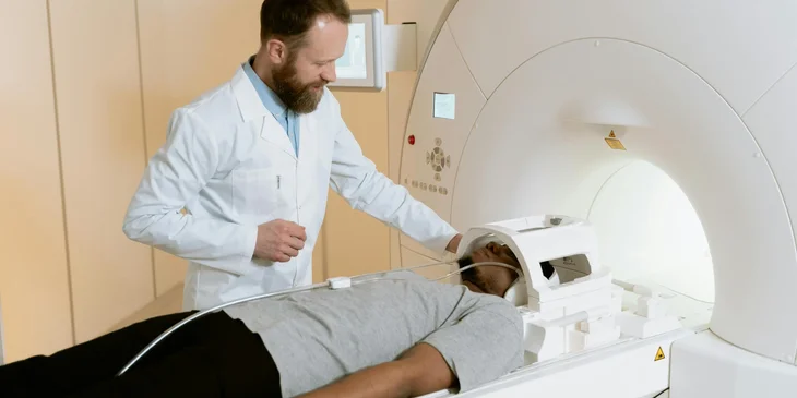 An MRI technologist assisting a patient into the MRI machine.