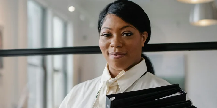 A woman carrying documents in folders.