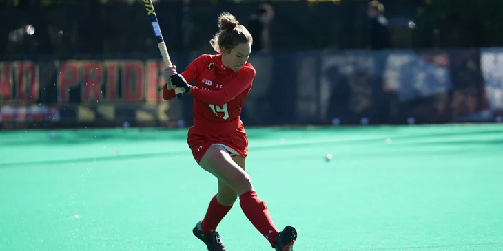 A woman playing hockey on fields during daytime.