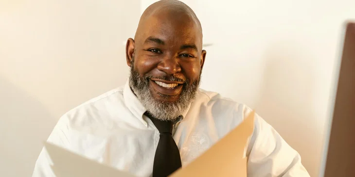 A man in a white long sleeves smiling.