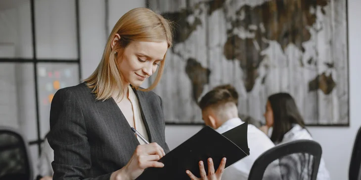 A woman taking notes in the office.