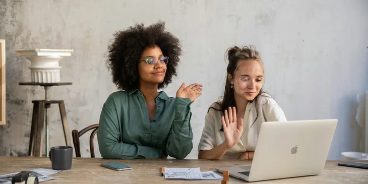 Two women in front of a laptop on a video call.