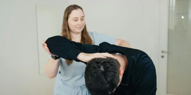 An occupational therapy assistant assisting a patient with stretching exercises.