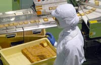 Un operario de envasadora trabajando en una fábrica de galletas.
