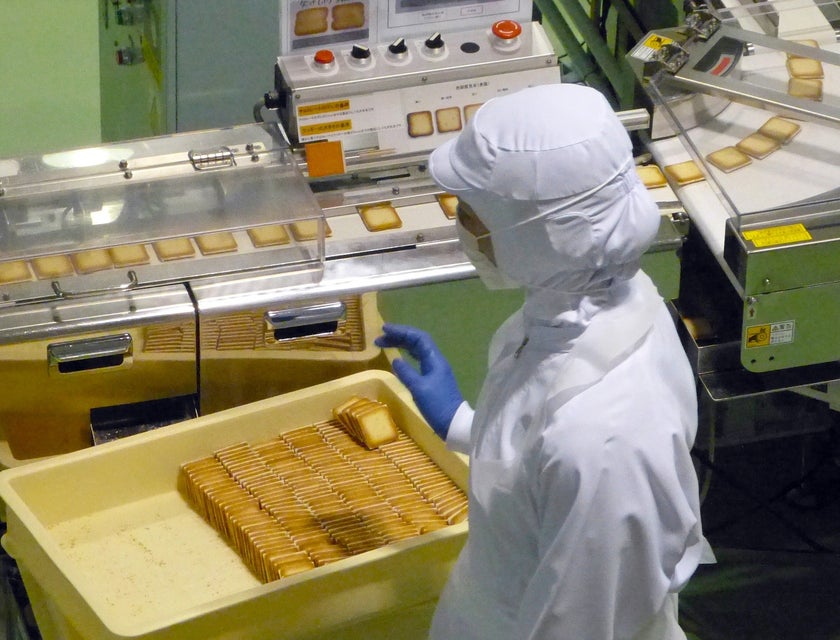 A packaging machine operator at work in a cookie factory.