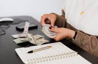 Una persona contando el dinero del pago de incentivo de una persona.