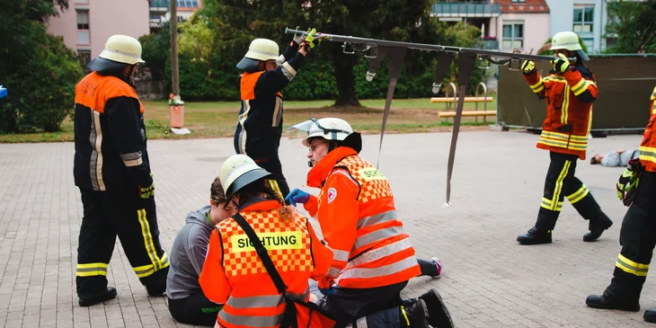 The paramedic team practices using first aid while conducting safety drills outdoors.