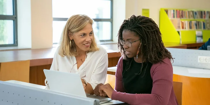 A paraprofessional assisting a student with their schoolwork.