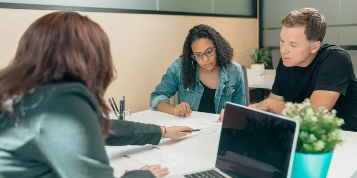 A parent coordinator having a conversation with parents about their child.