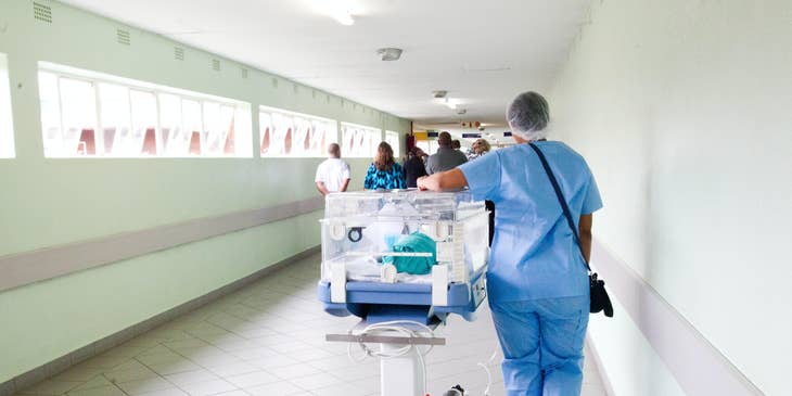A patient transporter moving a patient in a hospital.