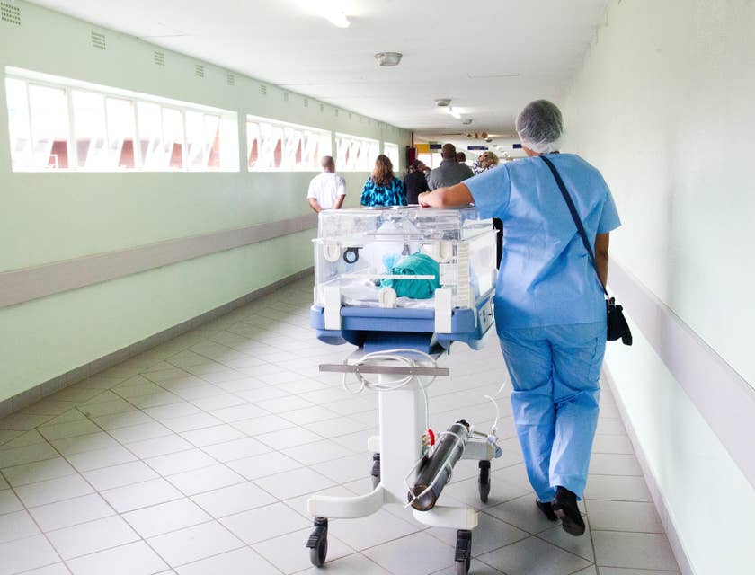 A patient transporter moving a patient in a hospital.