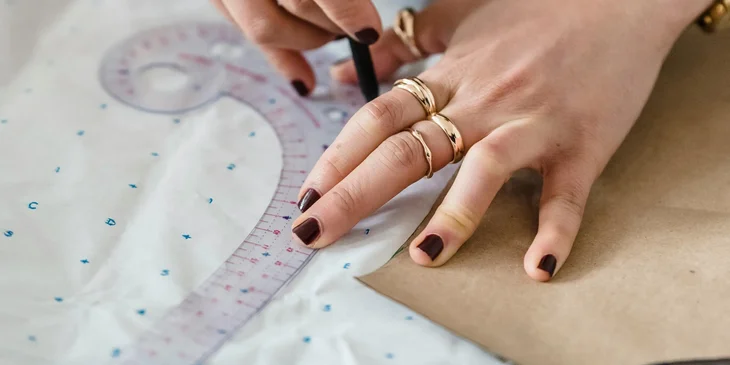A patternmaker creating product designs on a cloth material.