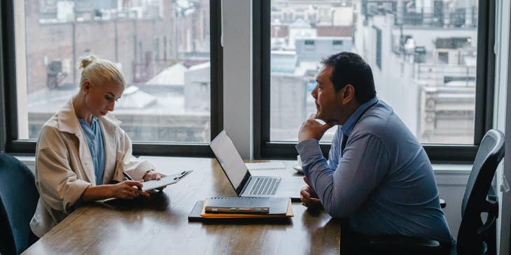 Two colleagues talking at a conference table