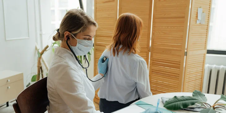 A physician uses a stethoscope to check the child's lungs.