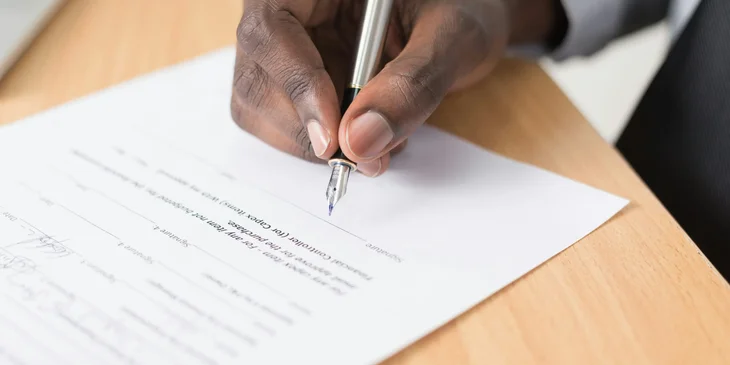 Un empleado firmando un acuerdo de rescisión.