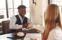 Hombre dando la mano a una mujer en una entrevista de trabajo.
