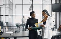 Dos oficinistas hablando de las prestaciones de sus empleados.