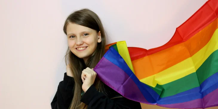A woman holding a Pride flag.