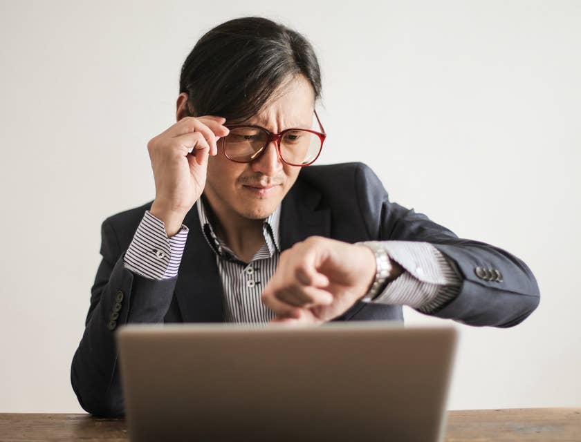 product manager behind laptop checking the time