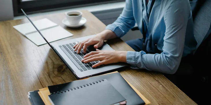 A program assistant replies to emails using her laptop.