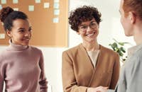 Una empleadora estrechando la mano del candidato de un  programa de empleados referidos.
