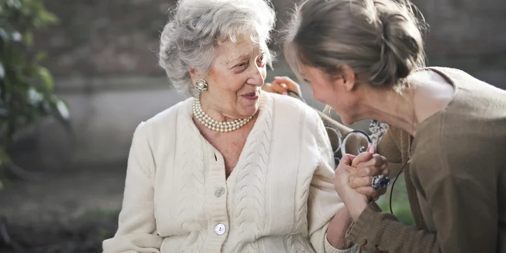 A caregiver assisting an elderly woman.