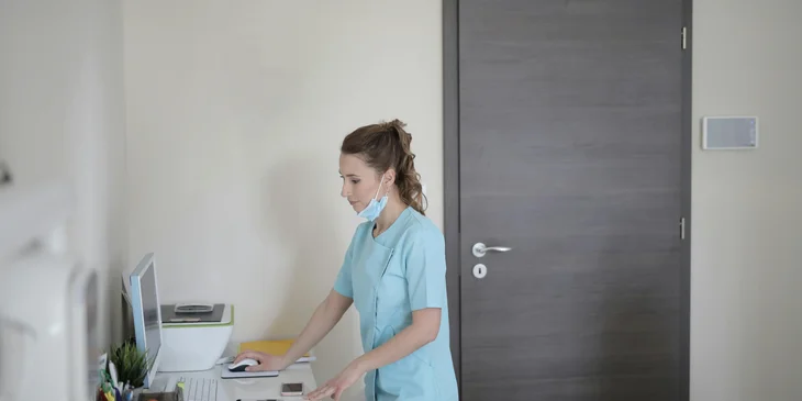 A medical worker entering a client's information into the database.