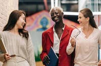 Tres ejecutivas caminando por una empresa hablando sobre la propuesta de valor para el empleado.