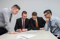 Cuatro hombres revisando beneficios laborales.