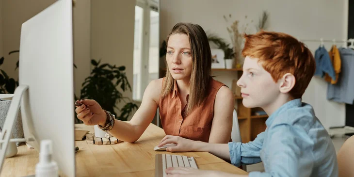 A speech teacher instructing a student through a computer.
