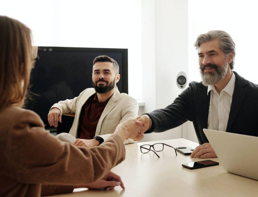 Tres colegas dan la bienvenida a un nuevo miembro a su equipo de reclutamiento.