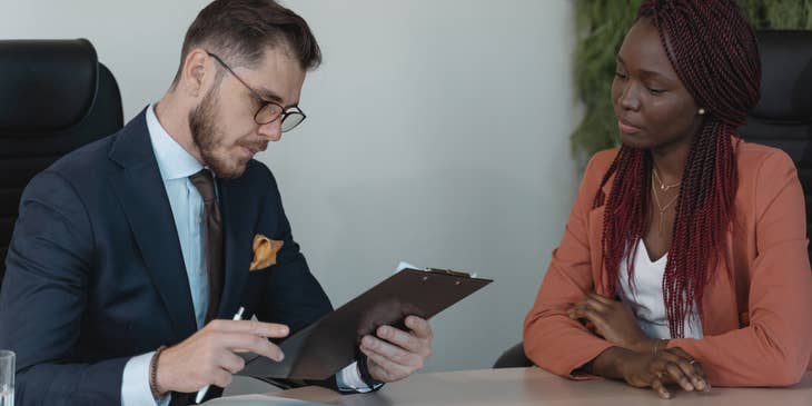 Two people in an office discussing recruiting strategies.