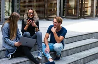Three people sitting on the stairs, engaged in conversation.