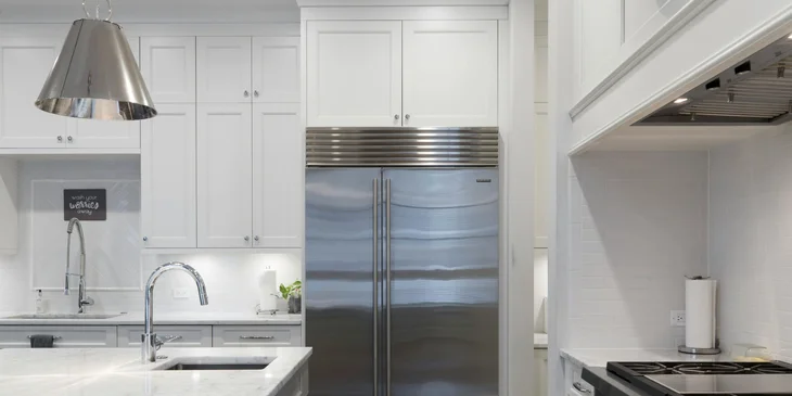 A refrigerator stands in the kitchen.