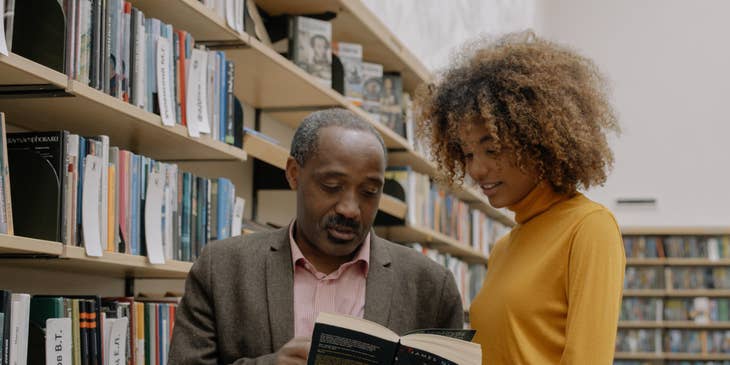 Research consultant working in a library with a fellow researcher.