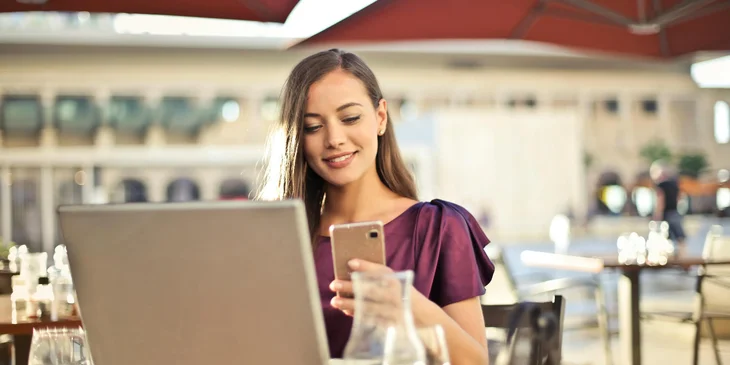 A restaurant manager working outdoors at her restaurant.