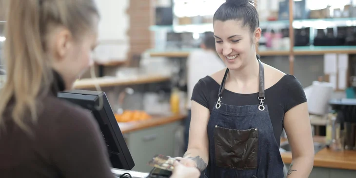 A woman paying with credit card.