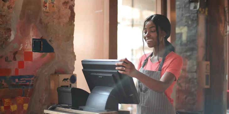 A young female working on a cash register.