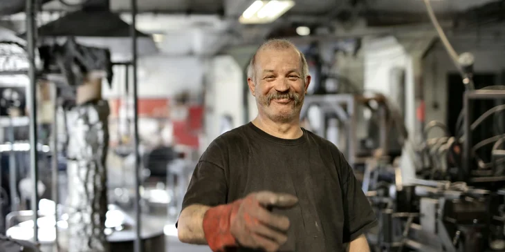 A worker smiling in a workshop.