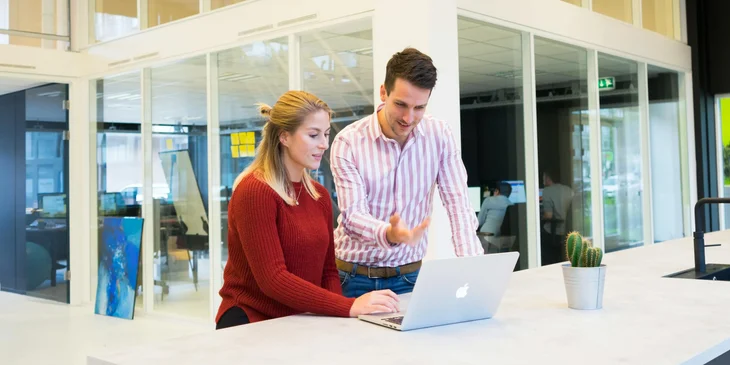 A man and a woman using a laptop.