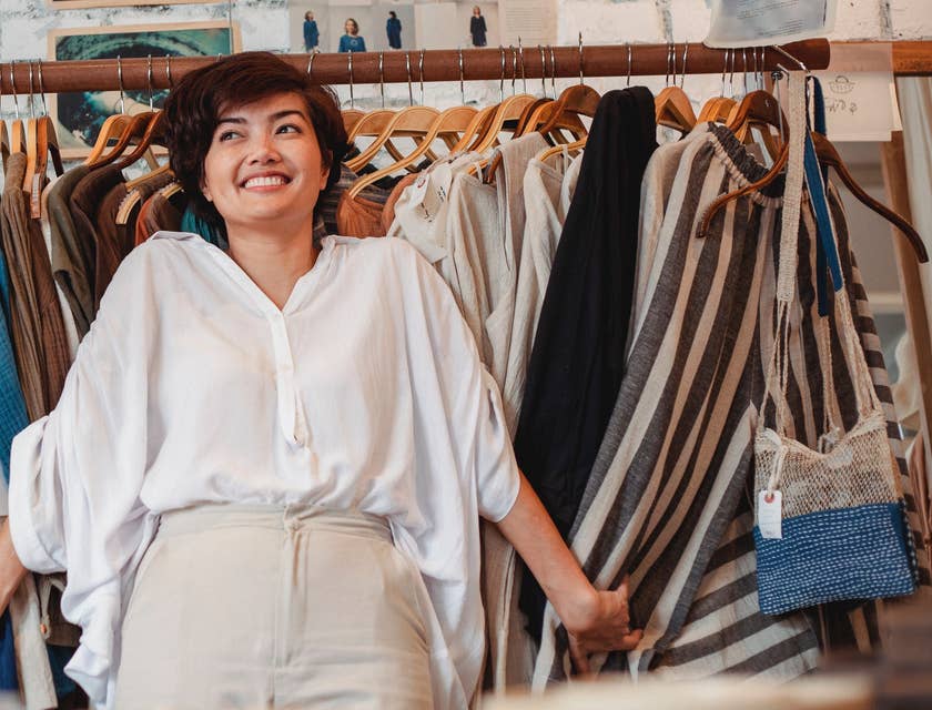 sales associate standing by a rack of clothes