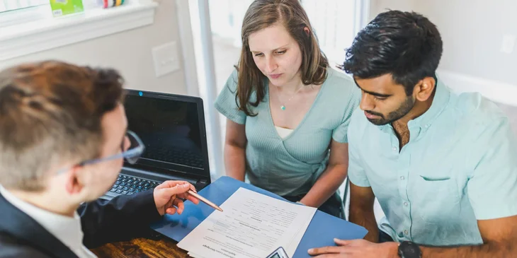 A sales consultant meets with clients to finalize a deal.