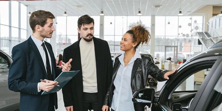 A sales agent explaining the details of the car.