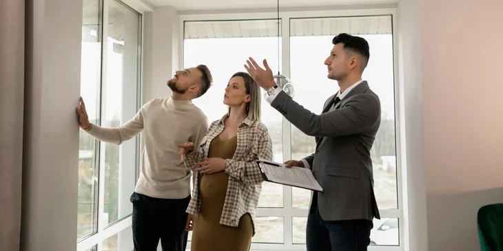 A real estate professional giving a tour to a couple interested in buying the house.
